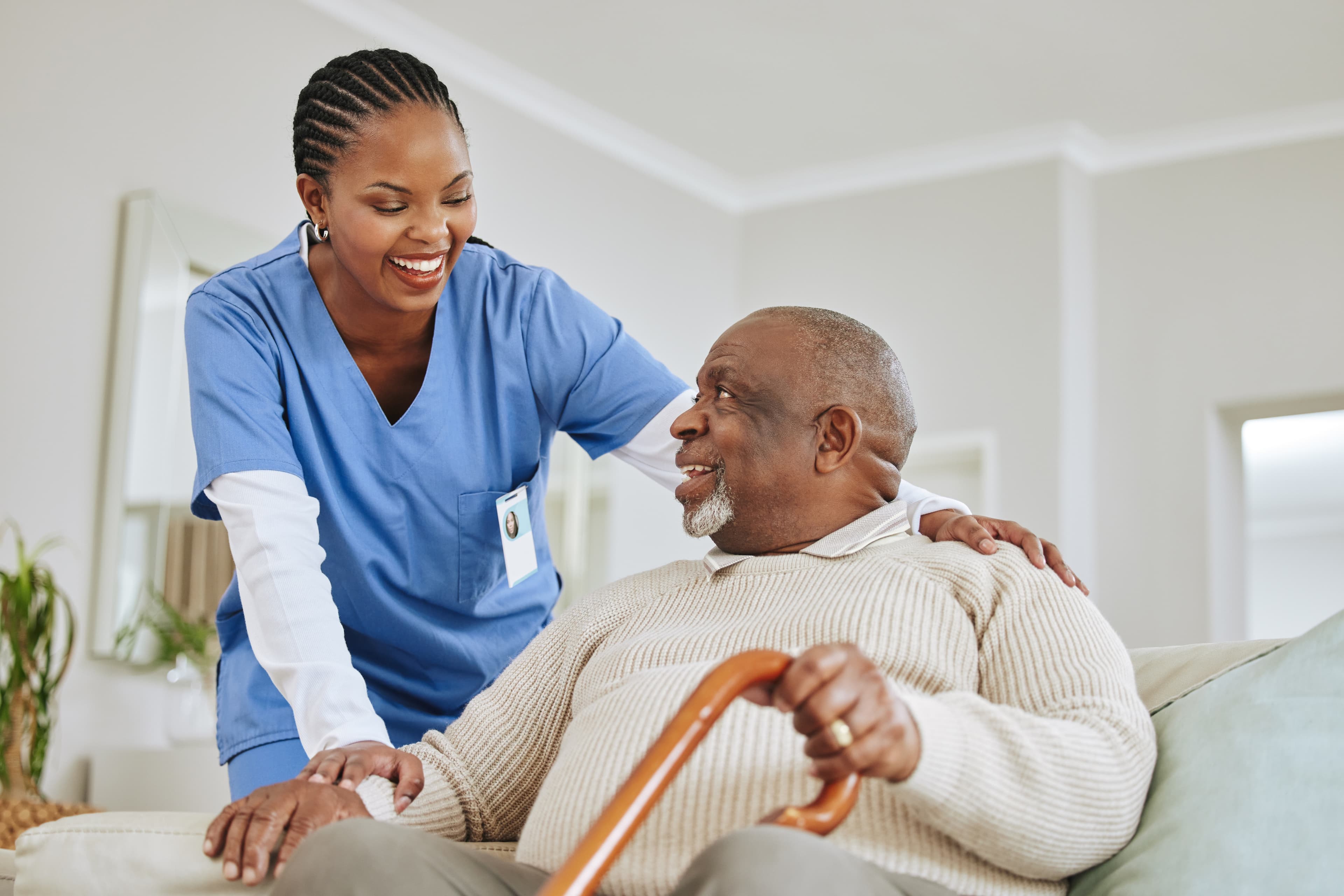 A nurse supporting an older man in his home