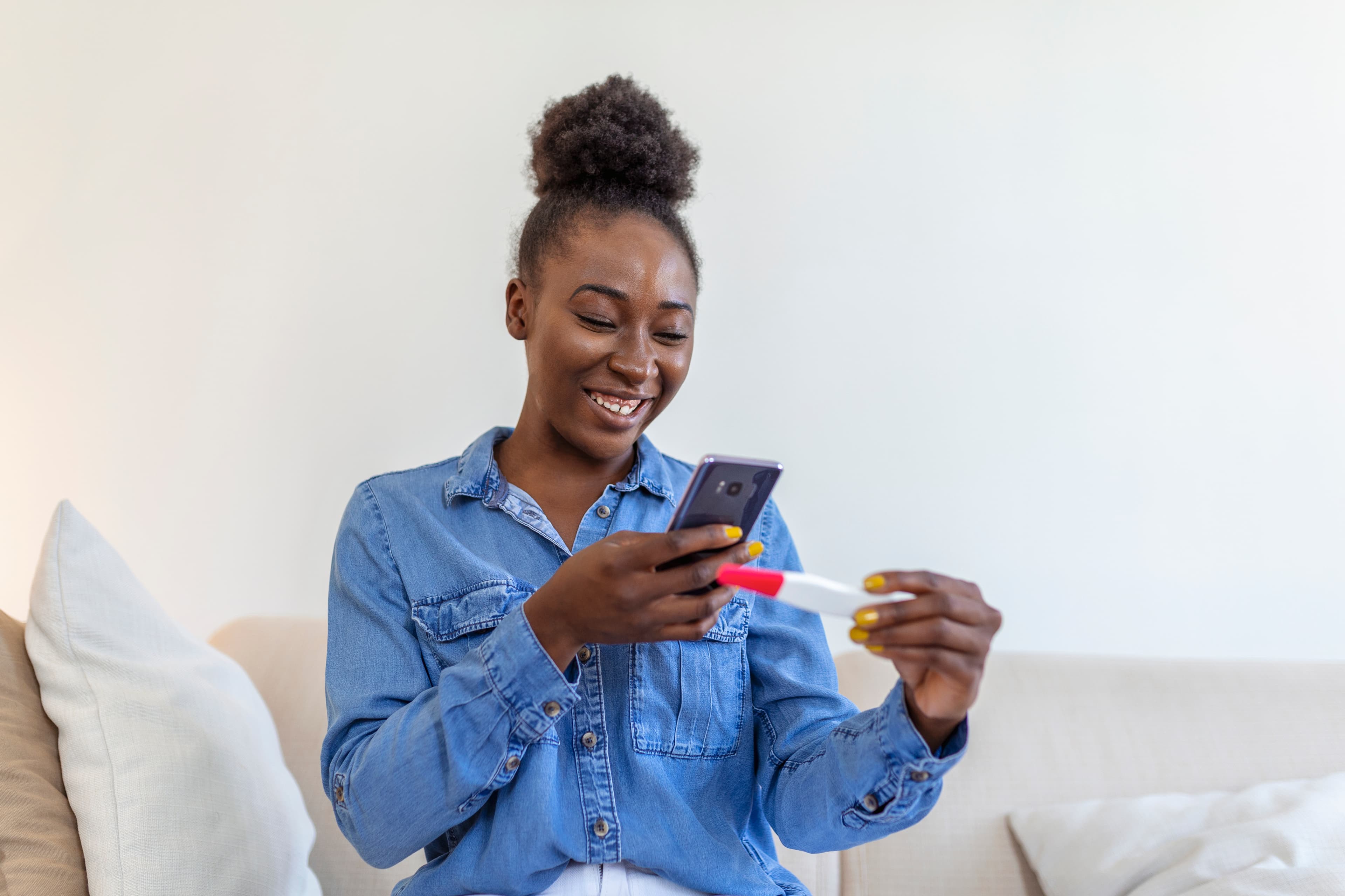 A woman using her phone while holding a home test
